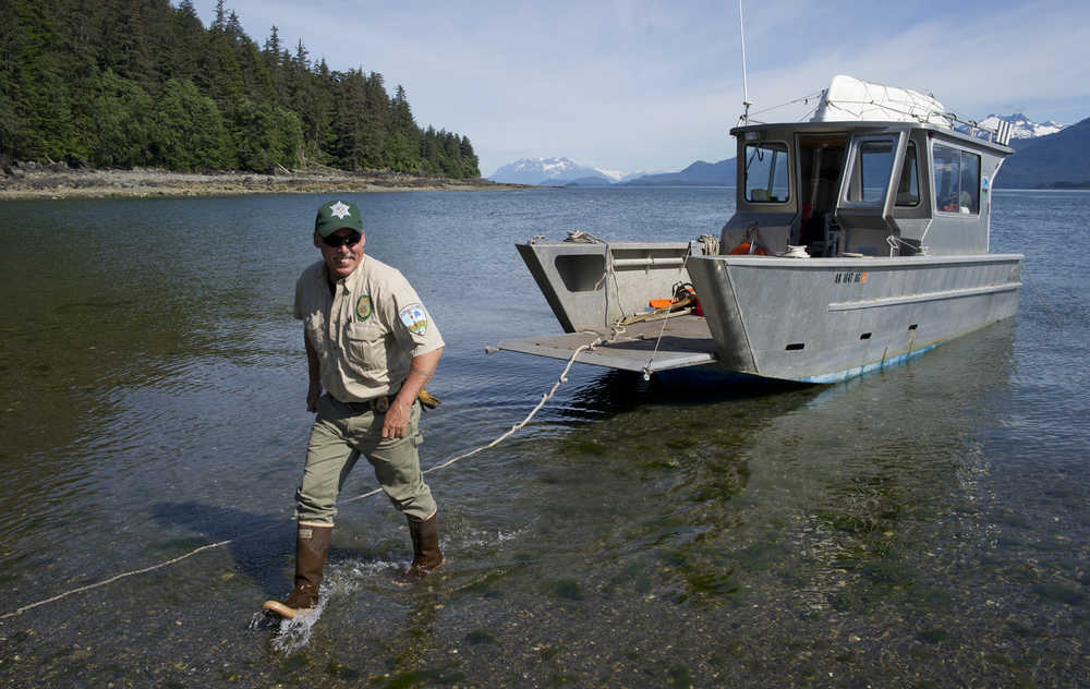 Kevin Murphy, right, chief ranger for the southeast area of Alaska State Parks, steps off a parks' boat to view the new Salamander Cabin at Halibut Cove on Shelter Island on Thursday.