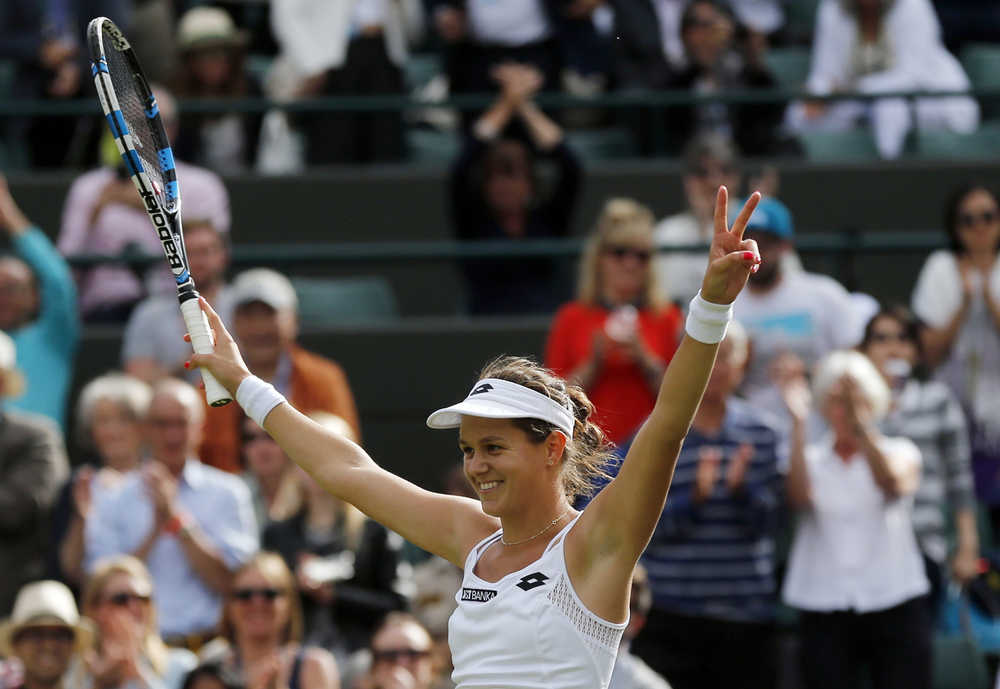 Jana Cepelova of Slovakia celebrates after beating Garbine Muguruza of Spain in their women's singles match on day four of the Wimbledon Tennis Championships in London, Thursday, June 30, 2016. (AP Photo/Ben Curtis)
