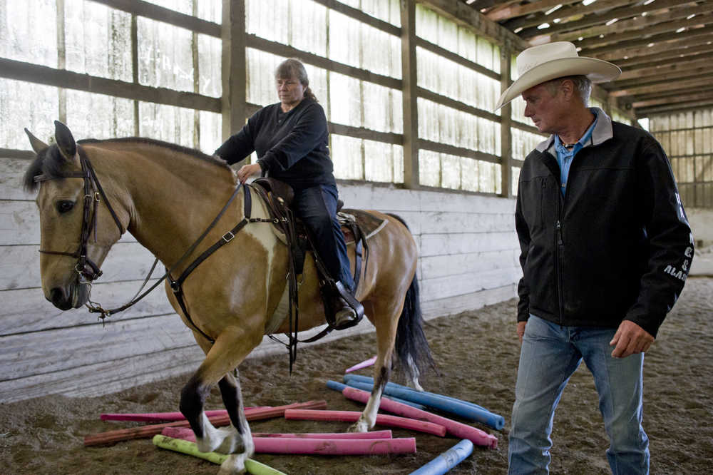 Bill Cameron trains Laura Baker on her horse, Maverick, at Swampy Acres on Thursday.