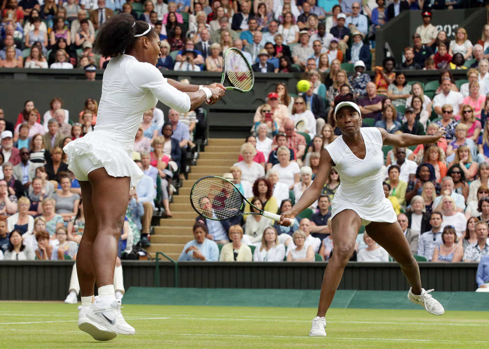 Serena Williams, left, and Venus Williams return to Yaroslava Shvedova of Kazahkstan and Timea Babos of Hungary during the women's doubles final at the Wimbledon Tennis Championships on Saturday in London.