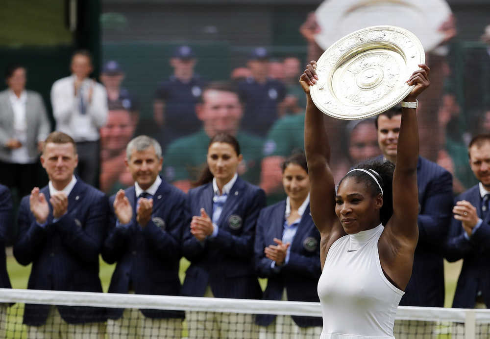 Serena Williams raises the trophy after beating Angelique Kerber of Germany in the women's singles final at the Wimbledon Tennis Championships on Saturday in London.