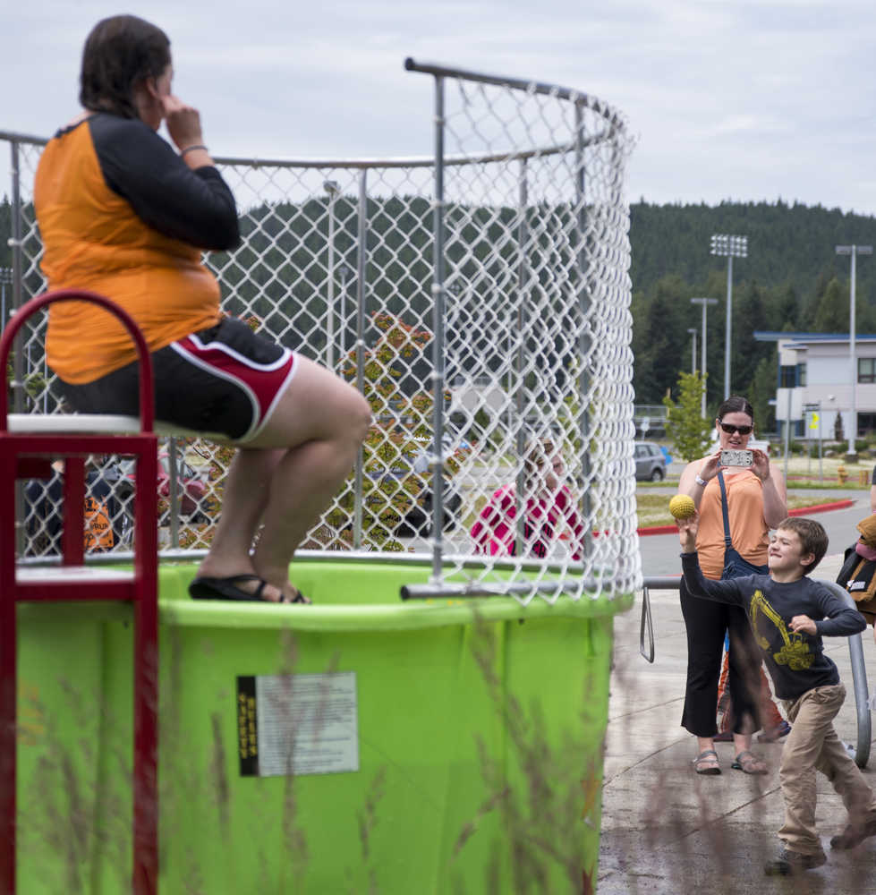 Torben Higgins, 7, right, throws a ball at the dunk tank lever as Julie Jackson, left, aquatics manager for the City and Borough of Juneau, awaits a dunk at the 6th Annual Rotary Day at the Pool at the Dimond Park Aquatic Center on Saturday afternoon. The pool held three free swims, with over 100 attendees at each swim.