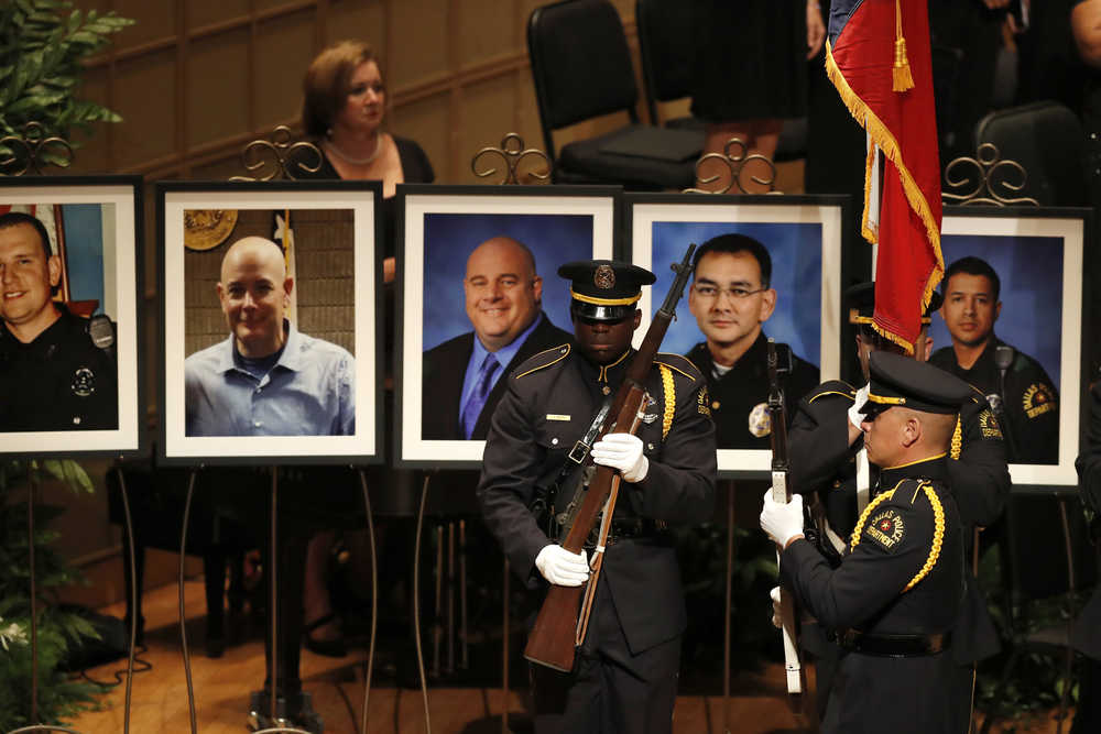 Portraits of the five fallen police officers are seen at rear as a memorial gets underway at the Morton H. Meyerson Symphony Center in Dallas, Tuesday, July 12, 2016, after the arrival of President Barack Obama. Five police officers were killed and several injured during a shooting in downtown Dallas last Thursday night.