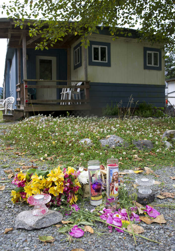 Candles and flowers sit in front of a Lemon Creek trailer in remembrance of Kristina Elizabeth Young on Wednesday. Young's body was found along the North Douglas shoreline on Tuesday.