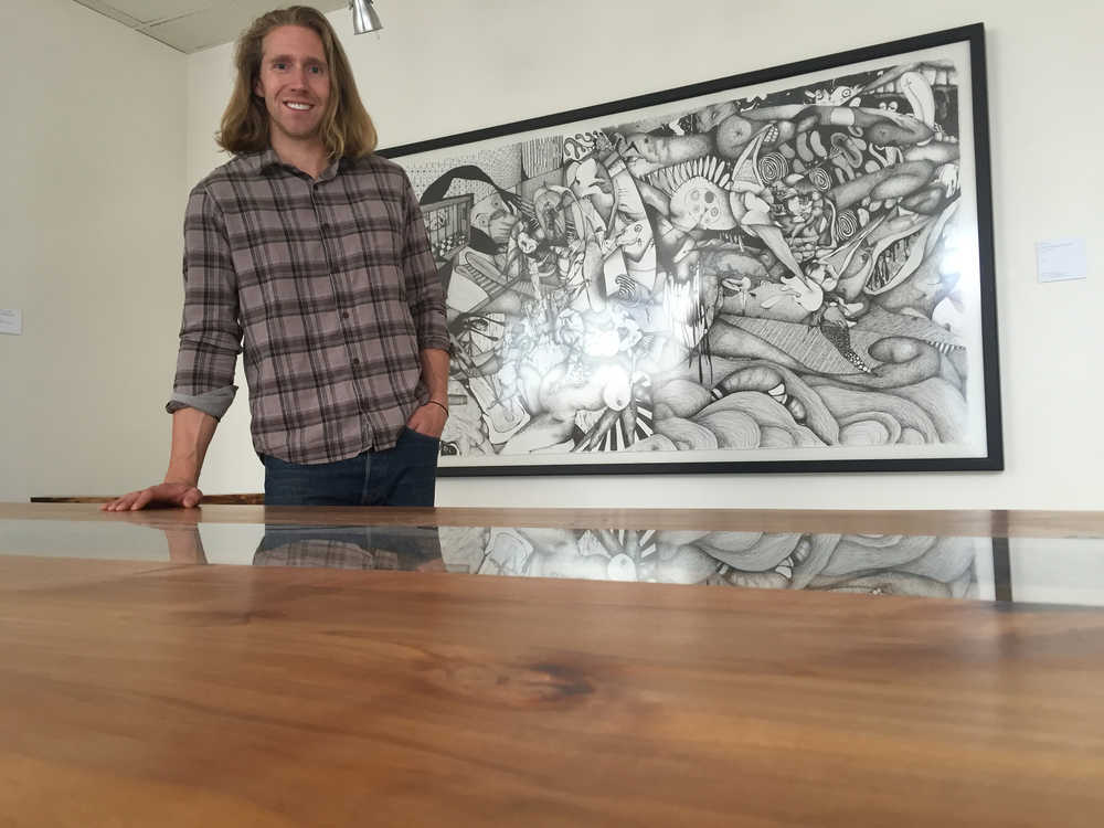 Reid Harris, owner of Northern Edge Craftworks, creates live-edge tables, benches, and other furnishings using locally sourced, sustainable wood. On the underside of each piece, he even stamps the GPS location where the tree was harvested. A show of his work will be up at The Canvas at REACH until July 26. This table incorporates live edge covered by glass, which is reflecting a piece of art by Abe Wylie. Mary Catharine Martin | Capital City Weekly