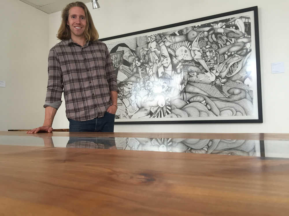 Reid Harris, owner of Northern Edge Craftworks, creates live-edge tables, benches, and other furnishings using locally sourced, sustainable wood. On the underside of each piece, he even stamps the GPS location where the tree was harvested. A show of his work will be up at The Canvas at REACH until July 26. This table incorporates live edge covered by glass, which is reflecting a piece of art by Abe Wylie. Mary Catharine Martin | Capital City Weekly