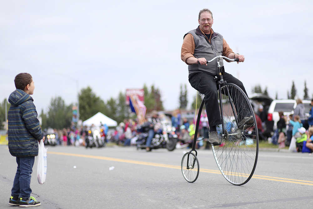 In this July 4 photo, Doug Field demonstrates how to ride his penny-farthing bicycle during a Fourth of July Parade in Kenai. Field's father purchased the bicycle, built by the now out-of-business Boneshaker company, on impulse in San Francisco in the 1970s.