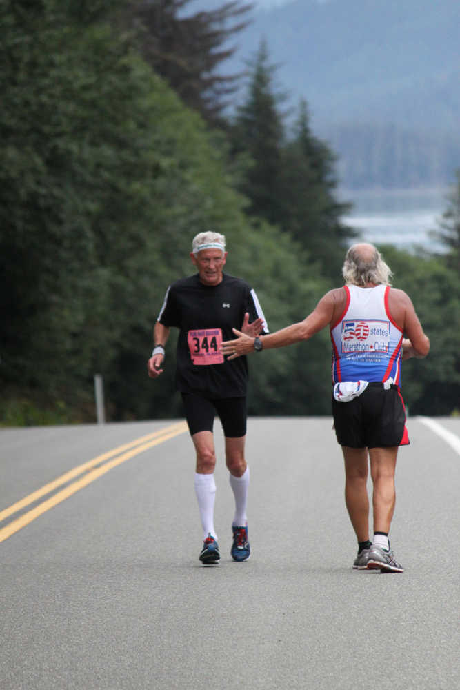 Richard DeCample receives a high five from a runner during the Frank Maier Marathon.