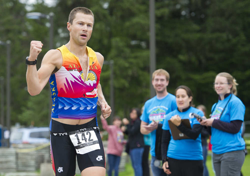 Mick Bakker of Anchorage pumps a fist as he crosses the finish line in the 8th annual Aukeman Sprint Triathlon at the University of Alaska Southeast on Saturday.