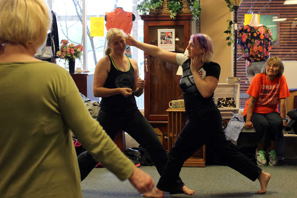 Brazilian Jiu-Jitsu purple belt instructor Harmony Armstrong demonstrates the "super slap" across her partner Jamee Wallis' ear after Armstrong escaped Wallis' attack. Armstrong was the first of three instructors to visit the Alaskan Dames shop in the Mendenhall Valley area as part of the "Dames in Defense" class series.