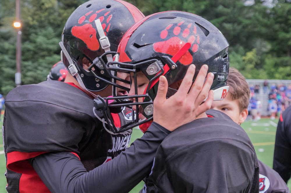 Crimson Bears junior Bubba Stults (left) and sophomore John Hamrick talk strategy during Saturday's game at Adair Kennedy Field.