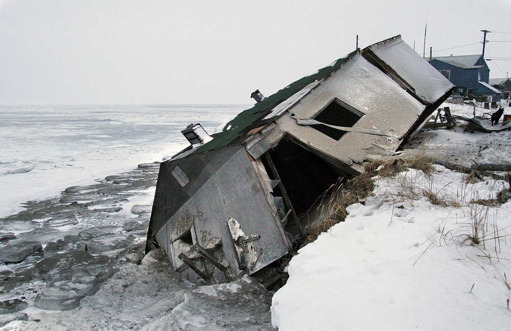 FILE - In this Dec. 8, 2006, file photo, Nathan Weyiouanna's abandoned house at the west end of Shishmaref, Alaska, sits on the beach after sliding off during a fall storm in 2005. Unofficial ballot returns from a special election held on Tuesday, Aug. 16, 2016, show a majority of Shishmaref's residents have voted in favor of relocating the community to the mainland amid erosion concerns. (AP Photo/Diana Haecker, File)