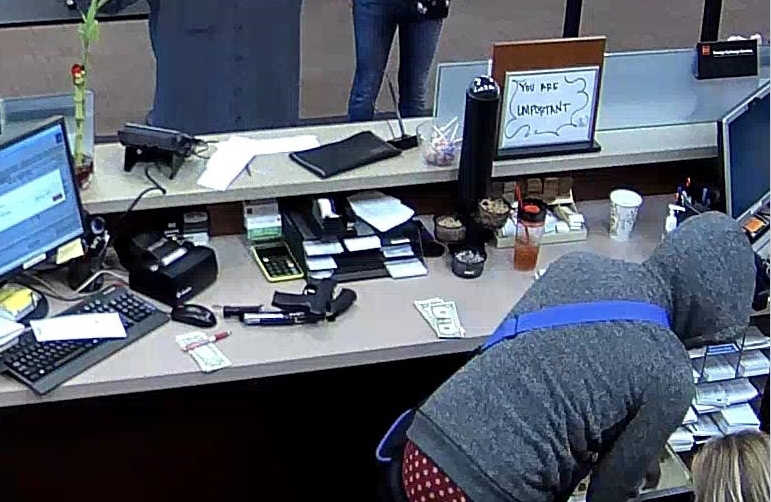In this Thursday photo, WellsFargo Bank security camera image released by the FBI shows two armed men robbing a bank Thursday morning on Anchorage's east side. One man was armed with a shotgun and the other with a handgun. The men at 10:14 a.m. entered the Wells Fargo Bank at 630 E. Fifth Avenue and demanded money. They carried off cash in a duffel bag with purple straps and left on foot. Witnesses say both were African-American and both wore sunglasses.
