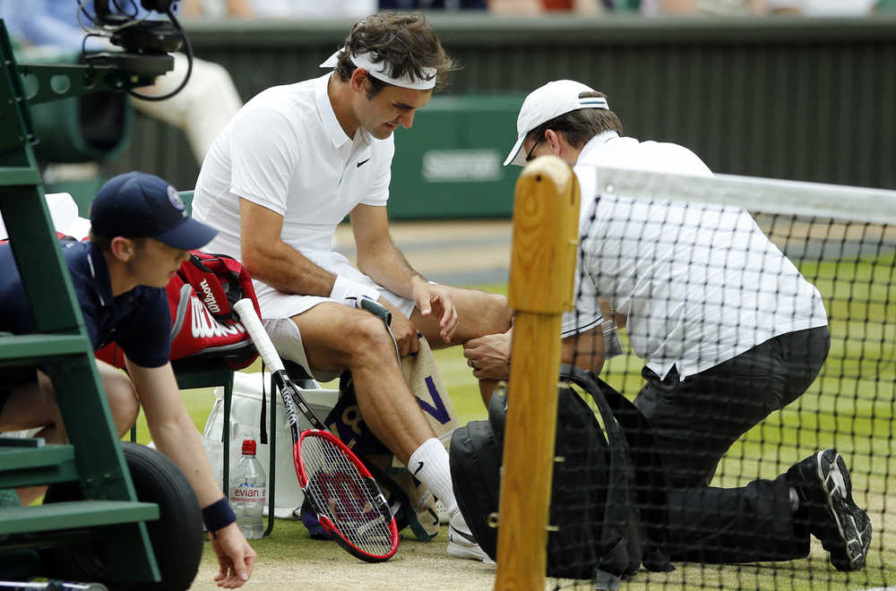 FILE - In this July 8, 2016, file photo, Roger Federer of Switzerland receives medical attention during his men's semifinal singles match against Milos Raonic of Canada at the Wimbledon Tennis Championships in London. Federer says he contemplated scenarios in which he would play in the Olympics and skip the U.S. Open, and vice versa. In the end, his balky left knee wouldn't allow him to do either. (AP Photo/Alastair Grant, File)
