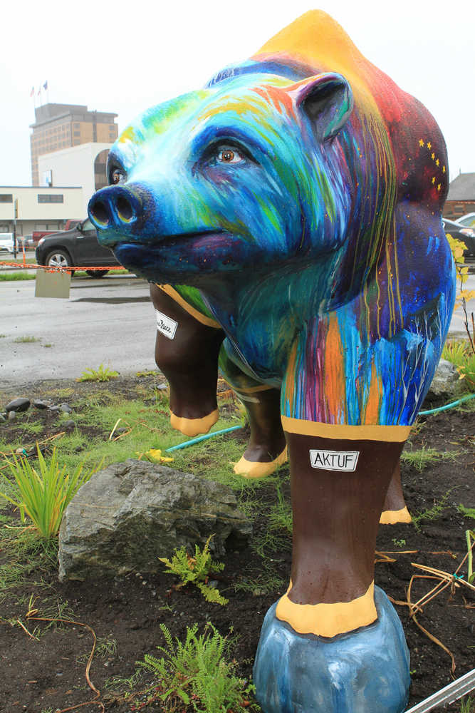 A life-size, fiberglass bear statue painted with nature scenes and rubber boots, part of a "Parade of Bears" display, stands in front of offices of Great Land Trust on Thursday, Aug. 25, 2016, in Anchorage, Alaska. The statues were installed to increase awareness of grizzly and black bears that live within the municipality of Anchorage and to highlight an international bear conference hosted by the city. (AP Photo/Dan Joling)