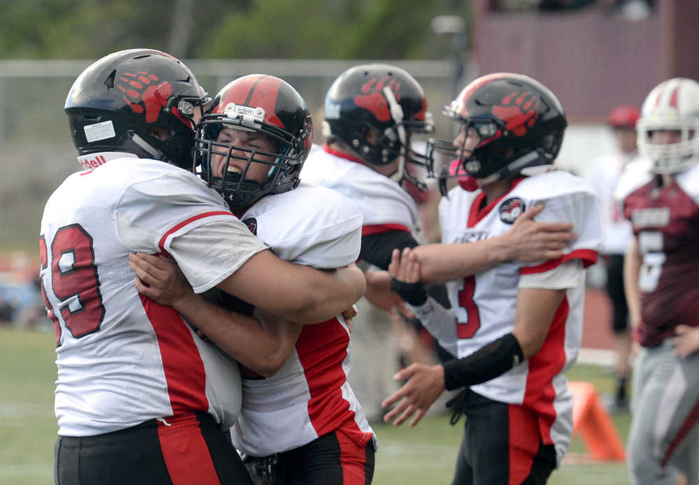 Juneau-Douglas junior Donavin McCurly (0) celebrates with junior John Elisoff (69) on Saturday, Aug. 27, 2016, during the Crimson Bears' 25-22, double-overtime win against Ketchikan High School at Esther Shea Field in Ketchikan.
