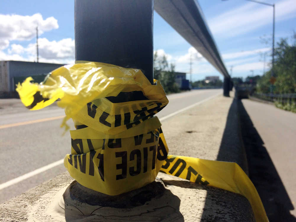 In this July 7, 2016 photo, police tape hangs from a hand rail near where two people were killed on the Ship Creek Trail in downtown Anchorage, Alaska. The double homicide is among nine unsolved cases this year in which people have been found dead in Anchorage parks, trails and on isolated streets. (AP Photo/Mark Thiessen)