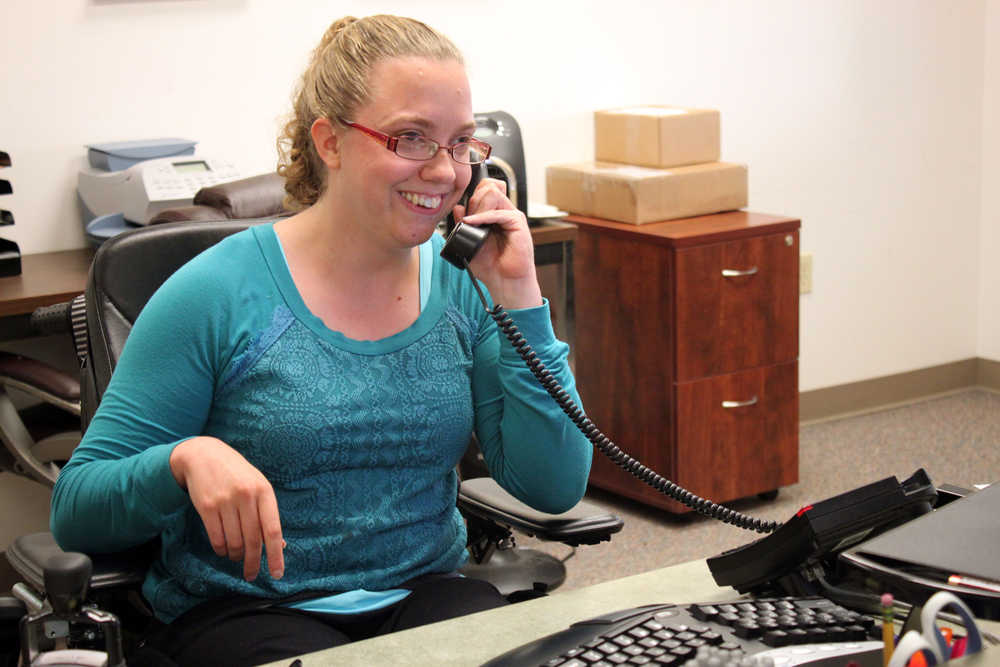 Sara Kveum, 28, has been receiving services from Hope Community Resources since she was a kid. Born with cerebral palsy, Kveum has a team of five to six help her with daily care and getting around in the community. Here, she's in her supported employment position at REACH, the agency that will soon take over her care when Hope closes.