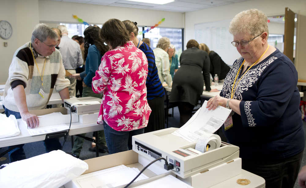 Sylvia Harvey, right, runs ballots through a vote counting machine in Juneau on Monday as election officials recount votes in the House District 40 primary race between incumbent Rep. Ben Nageak and challenger Dean Westlake.