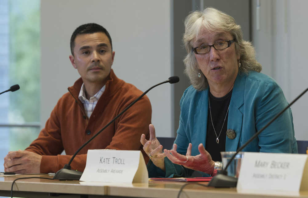 Assembly member Kate Troll speaks as her areawide challenger, Norton Gregory, listens during the Assembly forum at the Mendenhall Valley Public Library on Tuesday.