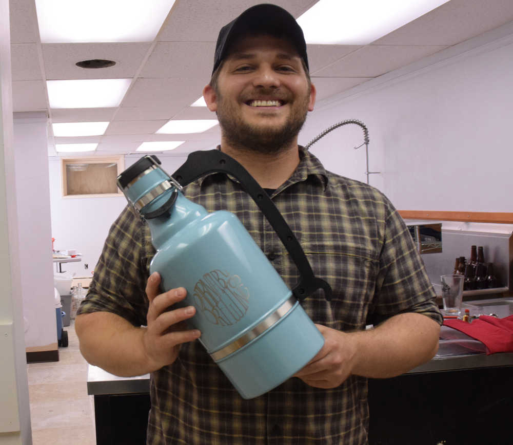 Brewer Matt Barnaby holds a growler emblazoned with the logo of his new business, Barnaby Brewing Co., which will hold an open house Saturday on North Franklin Street. The brewery is still seeking a federal license and will begin brewing beer early next year.