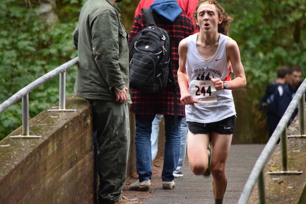 Juneau-Douglas High School sophomore Arne Ellefson-Carnes crosses the Indian River on his way to a first place finish at Saturday's Region V cross country championship meet in Sitka.