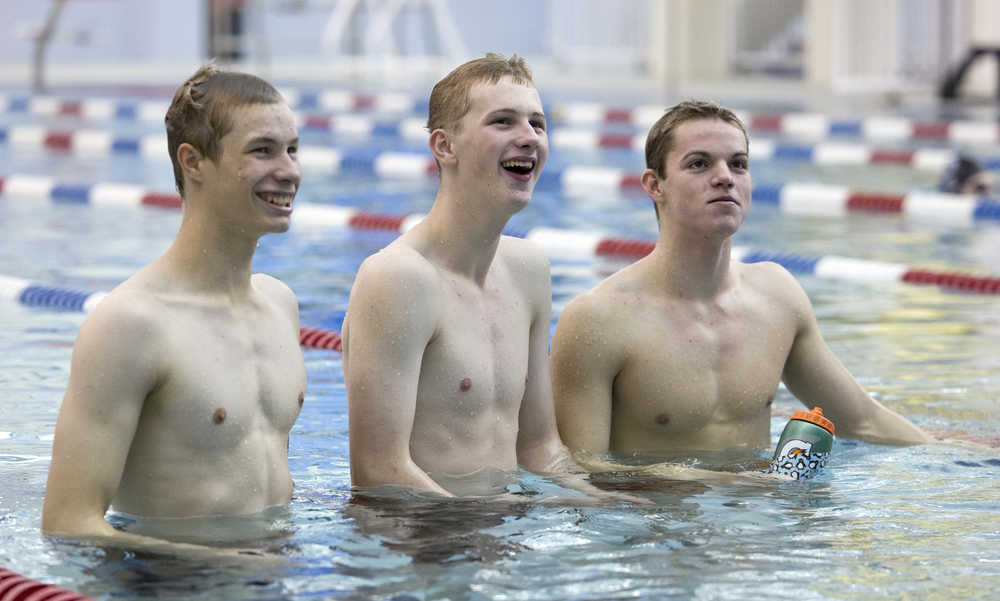 Spencer Holt, left, Christopher Ray, center, and Bergen Davis, all sophmores, take a break during Thunder Mountain High School swim team practice at the Dimond Park Aquatic Center on Wednesday.