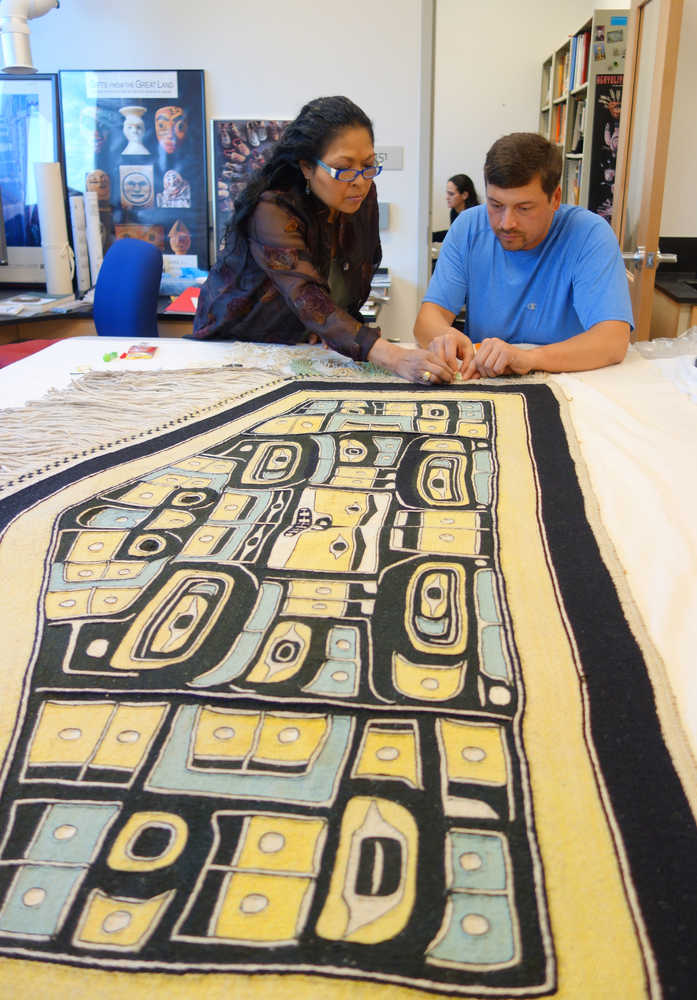 Chilkat weaver Anna Brown Ehlers and her apprentice Darrell J. Harmon add fringe to the diving whale blanket at the Alaska State Museum's conservation lab on Sept. 28.