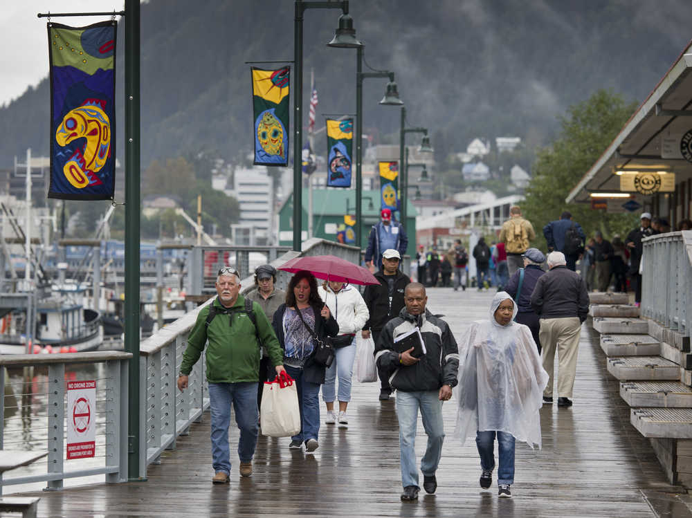 Cruise ship passengers walk in the rain back to their ship in early September.