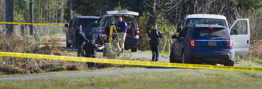 Juneau Police Department officers investigate the site where an adult male was found dead along the bike path near Mendenhall Loop Road and Egan Drive on Thursday.