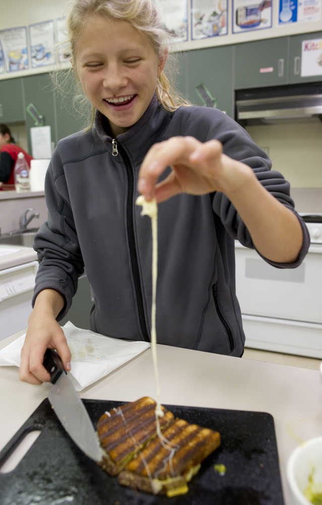 Eighth-grader Taylor Bentley examines her grilled-cheese sandwich during a Life Skills class at Dzantik'i Heeni Middle School on Thursday.