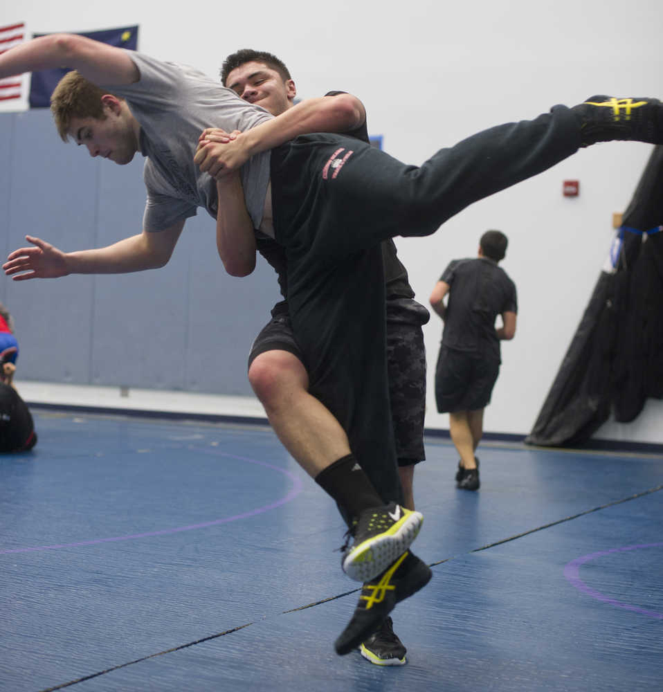 Carl Tupu throws Cody Weldon during wrestling practice at Thunder Mountain High School on Wednesday.