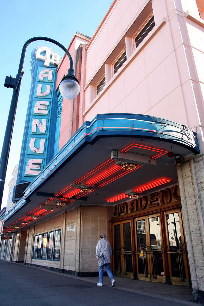 FILE - In this March 29, 2006, photo, a pedestrian walks past the 4th Avenue Theatre in Anchorage, Alaska. The owners of the art moderne-style theater, designed by the architect of Hollywood's famed Pantages Theatre, have applied to demolish the opulent vintage icon, prompting the Municipality of Anchorage to hasten efforts to protect historic buildings. (AP Photo/Al Grillo, File)