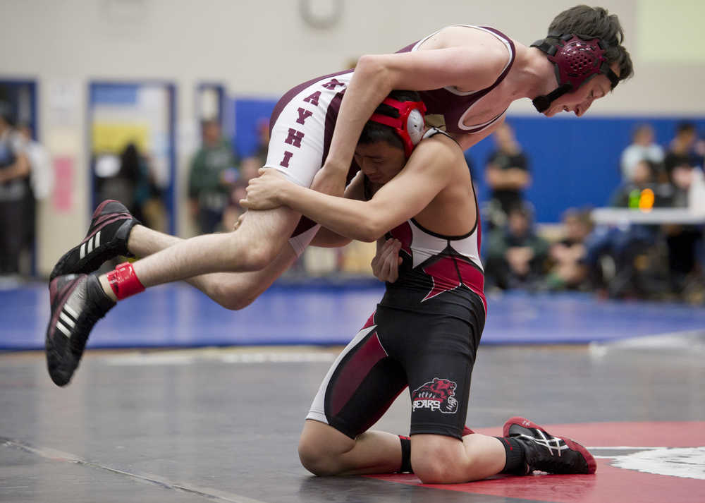 Juneau-Douglas' Ricky Ramirez lifts Ketchikan's Connor McCormick during their 106 weight bout in the Brandon Pilot Tournament at TMHS on Friday.