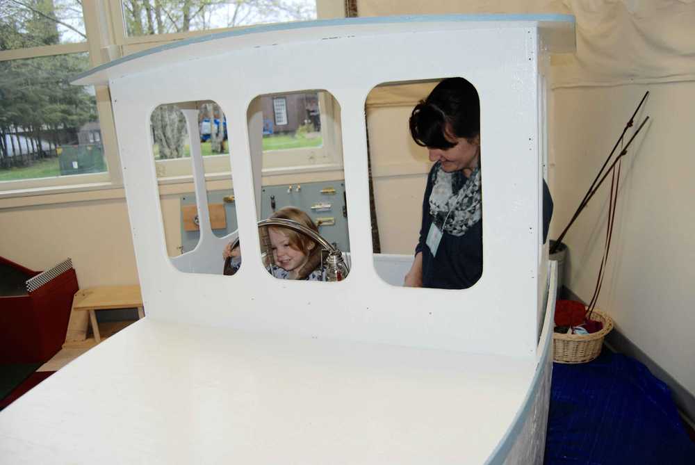 Winnie (1), plays on a boat at the Sitka Children's Museum alongside its founder, Jeanette Farah.