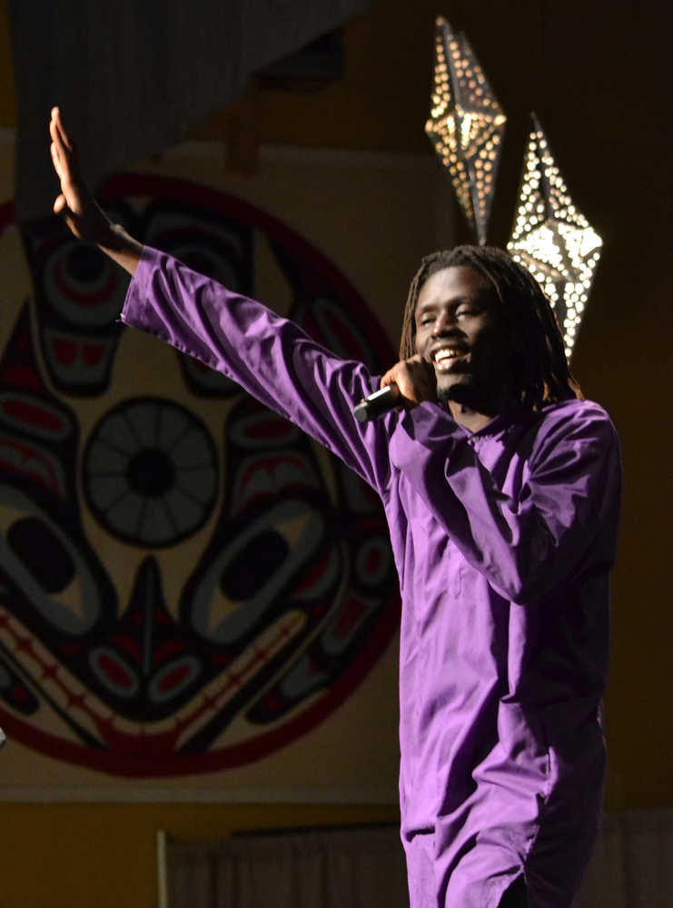 Emmanuel Jal waves his hand in the air while reciting spoken word poetry Wednesday night in the Juneau Arts and Culture Center.