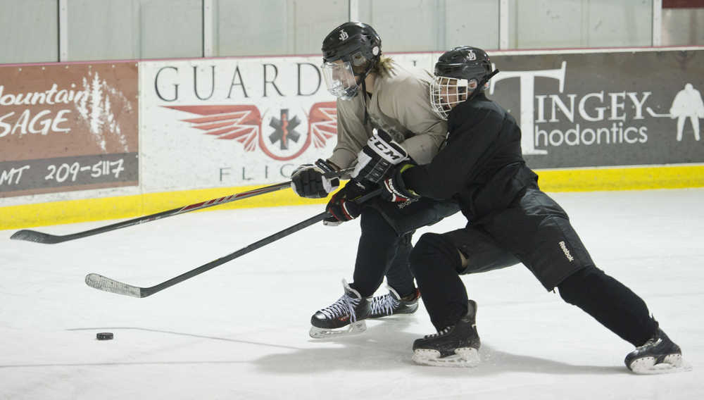 Ryan Liebelt, left, and Cahal Morehouse battle for the puck during Juneau-Douglas High School hockey practice at Treadwell Arena on Wednesday, Nov. 2, 2016.