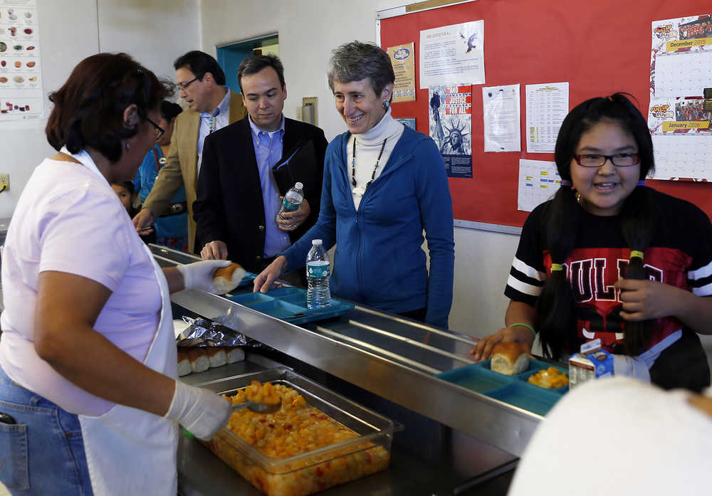FILE - In this Thursday, Jan. 14, 2016, file photo, Carol Curley serves lunch to Bureau of Indian Education Director Charles "Monty" Roessel, from left, Acting Assistant Secretary for Indian Affairs Lawrence S. Roberts, Secretary of the Interior Sally Jewell and fifth-grade student Meishi Harrison at Cove Day School in Cove, Ariz. Interior Secretary Sally Jewell on Wednesday, Nov. 2, 2016, named Tony Dearman, who is Cherokee, to head the Bureau of Indian Education, a division of the U.S. Interior Department that has oversight of nearly 200 schools in some 20 states. (Jon Austria/The Daily Times via AP, File)