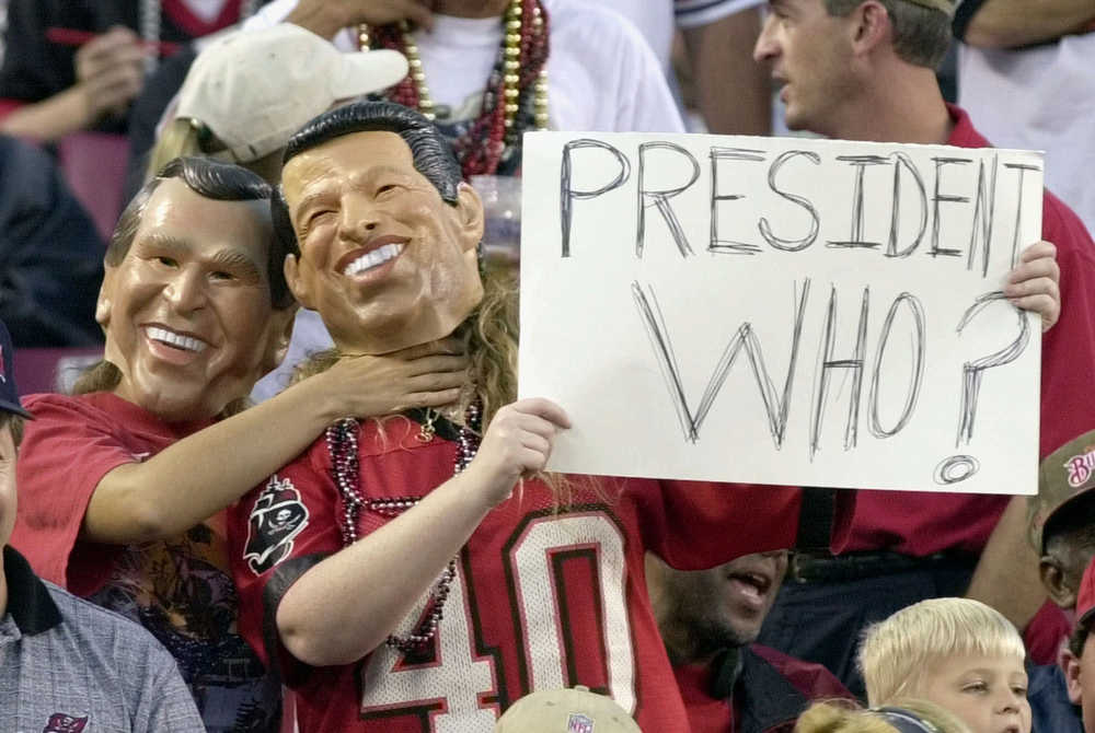 FILE - IN this Nov. 12, 2000 file photo, fans, one dressed as Republican presidential candidate Texas Gov. George W. Bush, left, playfully chokes a fan dressed as Democratic presidential candidate Vice President Al Gore, during the Tampa Bay Buccaneers game against the Green Bay Packers in Tampa, Fla. What happens if America wakes up on Nov. 9 to a disputed presidential election in which the outcome turns on the results of a razor-thin margin in one or two states, one candidate seeks a recount and the other goes to court? (AP Photo/Steve Nesius, File)