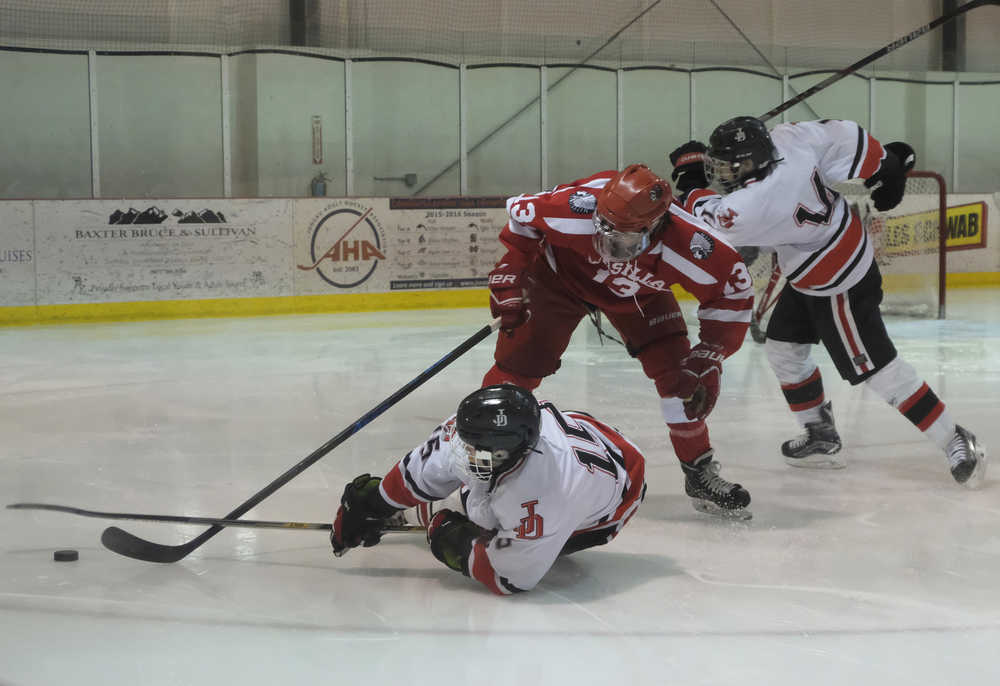 Juneau-Douglas High School's Cahal Morehouse  (15)  slides while competing for the puck with Wasilla's Alex Engan (13) as teammate Joseph Monsef (14)  scrambles to take control of the puck in Friday's game at Treadwell Ice Arena. Wasilla won 9-3.
