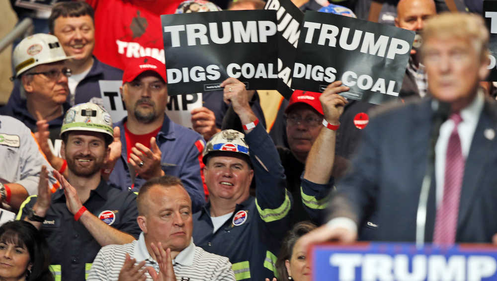 In this file May 5, 2016 photo, coal miners wave signs as Republican presidential candidate Donald Trump speaks during a rally in Charleston, West Virginia. Trump's election could signal the end of many of President Barack Obama's signature environmental initiatives. Trump has said he loathes regulation and wants to use more coal and expand offshore drilling and hydraulic fracturing.