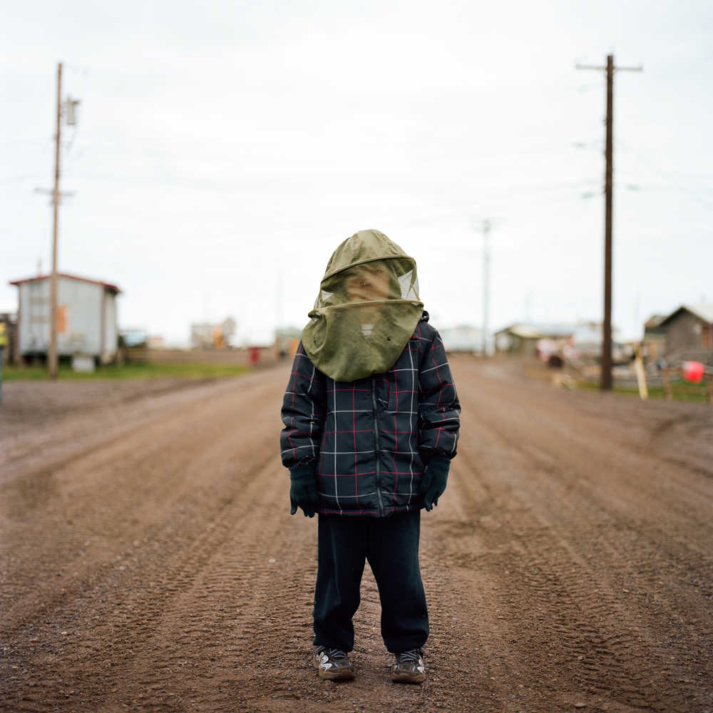 A boy in Wainwright, Alaska, wearing a mosquito net.