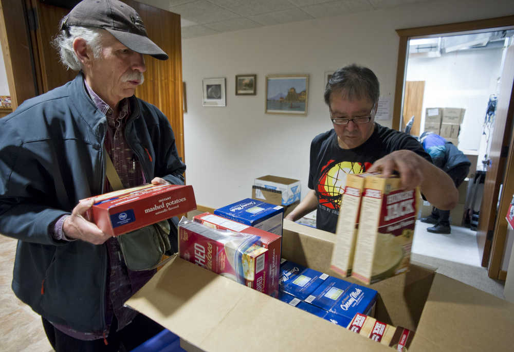 Mike Ricker, left, and Michael Spoon of The Glory Hole take stock of food for the soup kitchen's Thanksgiving dinner meals at its storage site at Holy Trinity Episcopal Church on Tuesday.