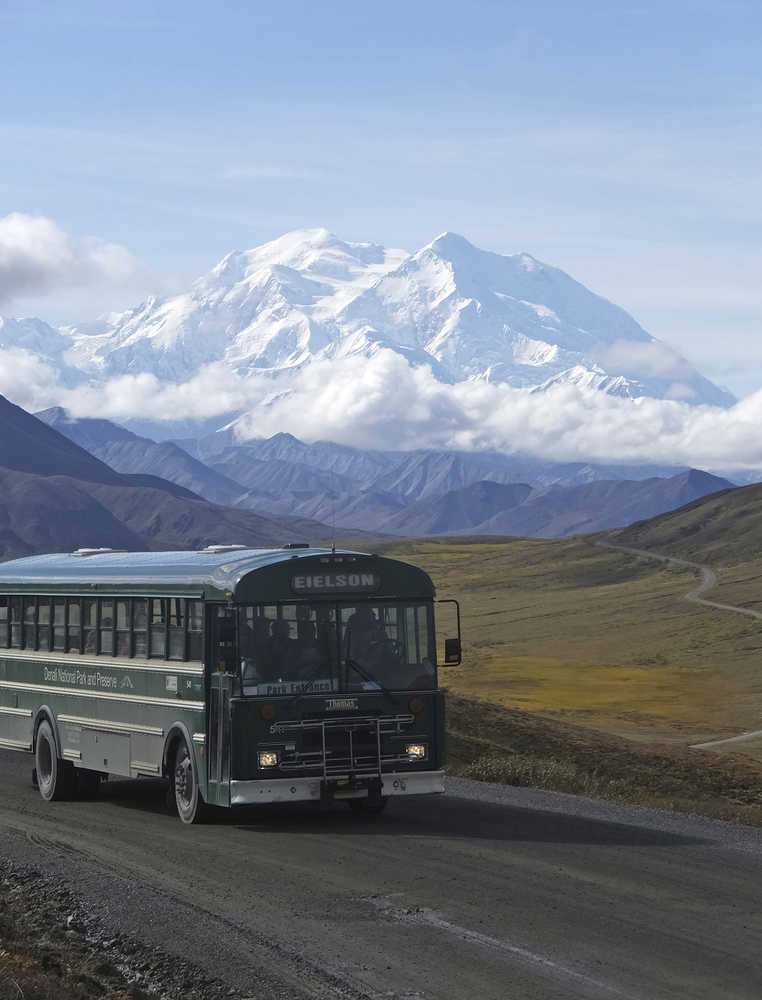 In this Aug. 26, 2016, photo, a shuttle bus carrying tourists makes its way along the park road with North America's tallest peak, Denali, in the background, in Denali National Park and Preserve, Alaska. President Barack Obama's administration in 2015 renamed the peak to its Athabascan name in a nod to Alaska Natives. As a candidate for president, Donald Trump tweeted a vow to change the mountain's name back to Mount McKinley. It's not yet clear whether Trump, now the president-elect, will act. (AP Photo/Becky Bohrer)
