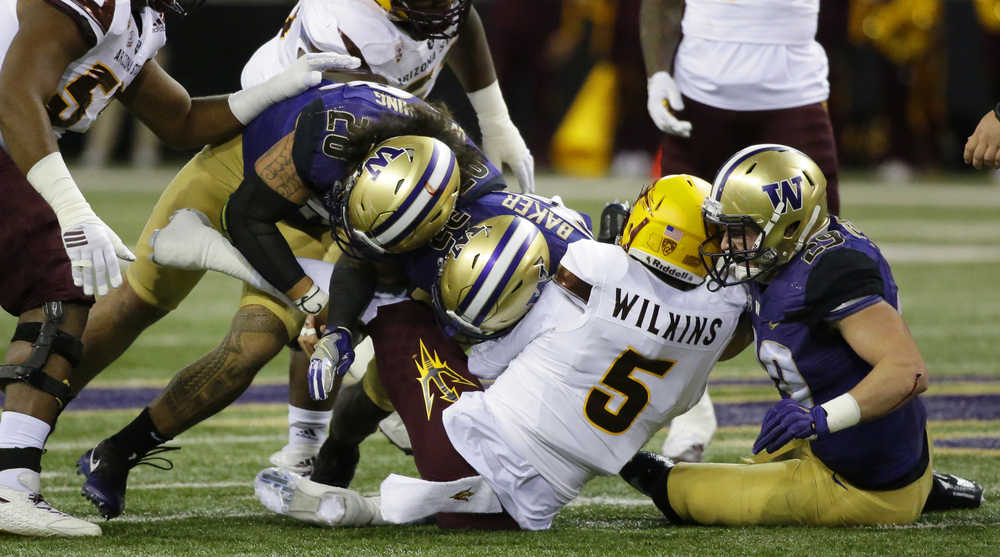 Arizona State quarterback Manny Wilkins (5) is sacked by Washington defensive back Budda Baker, third from right, with help from linebacker Connor O'Brien, right, and linebacker Psalm Wooching, left, in the first half of an NCAA college football game Saturday, Nov. 19, in Seattle. (Ted S. Warren | The Associated Press)