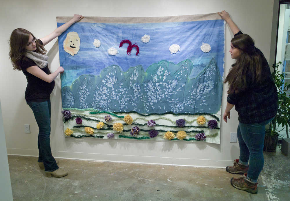 The Canvas Ceramics Studio Manager Mercedes Muñoz, left, and Artist-in-Residence Emma Davidson prepare to hang a work by Gary Peterson, Joann Sam and Andrea Short in The Canvas Gallery on Tuesday, Nov. 29, 2016, in preprepation of Friday's Gallery Walk. Davidson has been teaching artists at The Canvas creative ways to use silk, wool, and felt, while also encouraging the development of artists' personal styles and artistic messaging. The exhibit showcases the work of 10 artists and will be on view for the month of December.