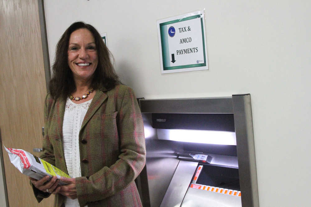 This Nov. 14 photo shows Kelly Mazzei, revenue audit supervisor for the state of Alaska tax division, posing with a deposit safe intended for marijuana businesses to pay their taxes in cash in downtown Anchorage. It's the only in-person drop-site for cash tax payments for marijuana businesses. Banking remains an issue for legal pot businesses in Alaska, since marijuana is still considered an illegal drug on the federal level.