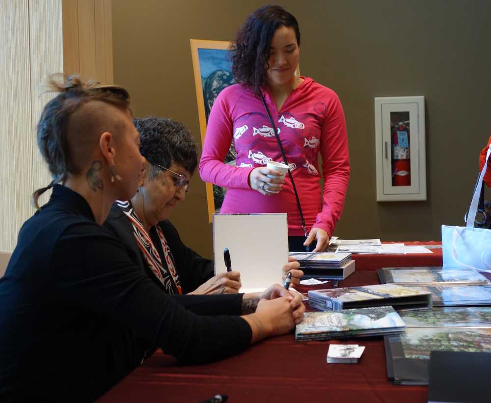 Crystal Worl, illustrator of the newly released two-book Tlingit alphabet, gets books signed by author Pauline Duncan and ilustrator Lindsay Carron.