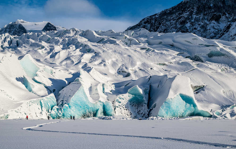 People walk on the frozen Mendenhall Lake along the face of the Mendenhall Glacier on Saturday.