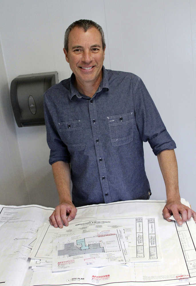 FILE - In this Oct. 5, 2016 file photo, Bryant Thorp poses with plans for his marijuana retail store, Arctic Herbery, in Anchorage, Alaska. The first retail marijuana store in Alaska's largest city is set to open Thursday, Dec. 15, 2016, and so many people are expected at the small store that shuttle buses will ferry customers in. Owner Bryant Thorp has set the opening for high noon at Arctic Herbery, a small nondescript shop in a busy industrial and residential area of midtown Anchorage. (AP Photo/Mark Thiessen, File)